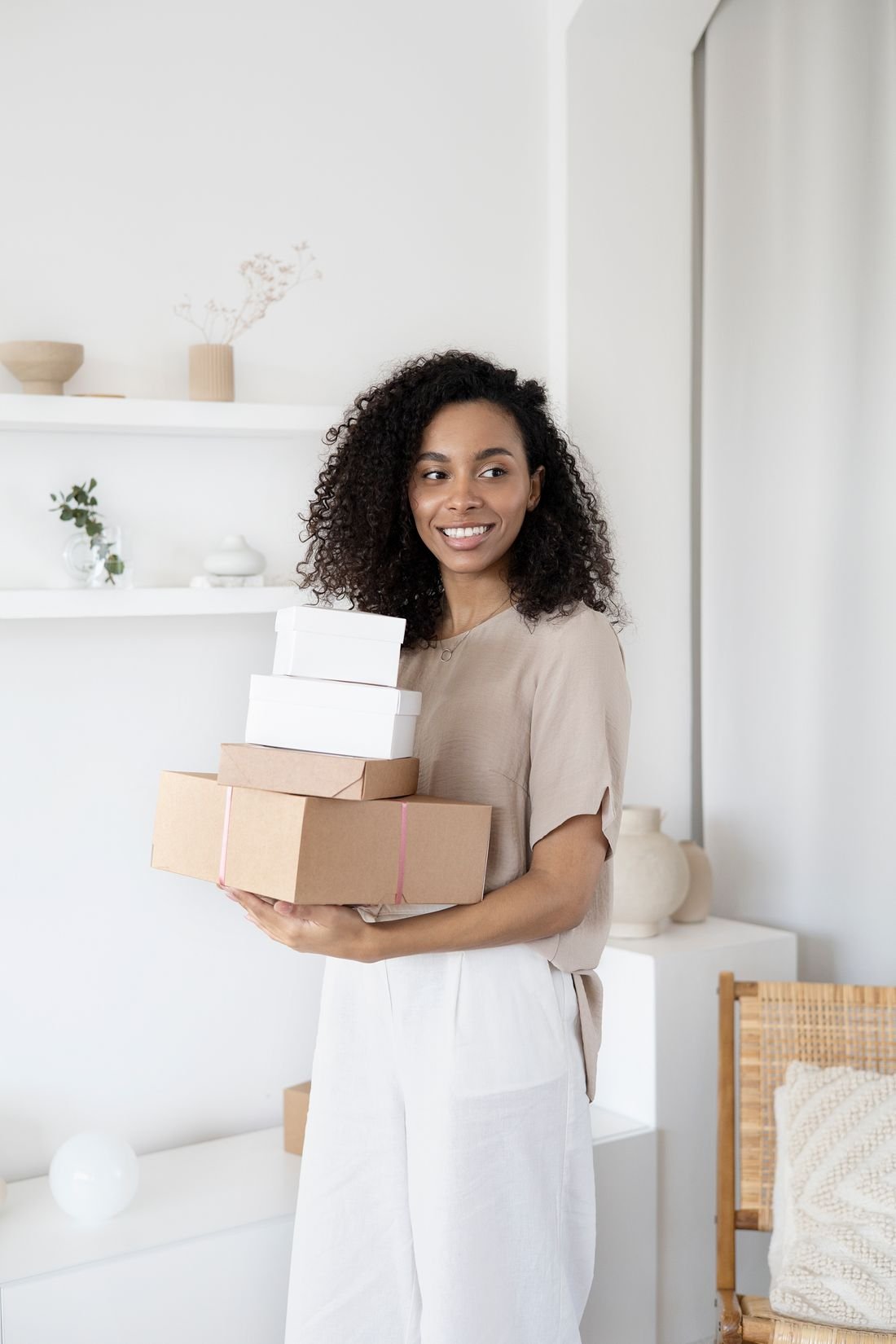Emprendedora con una pila de cajas de envío en brazos